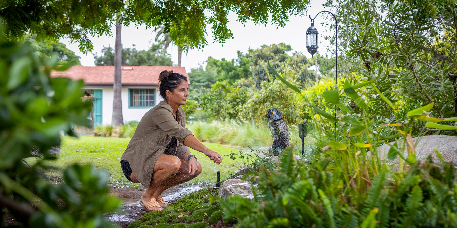 woman adjusting in-ground sprinkler