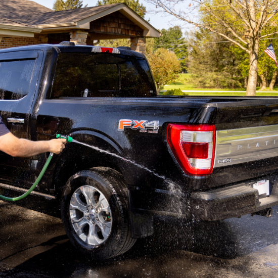 man spraying off truck with rain bird nozzle
