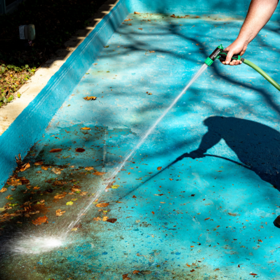 man spraying sidewalk using rain bird nozzle