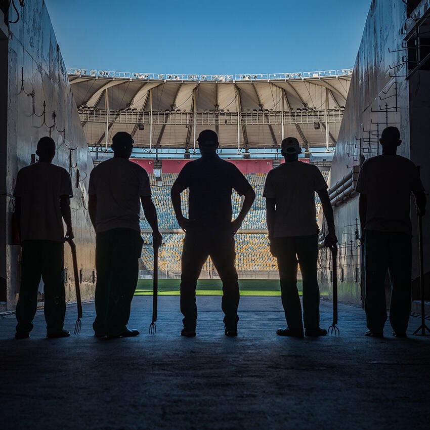 Silhouette of 5 guys at entrance of stadium