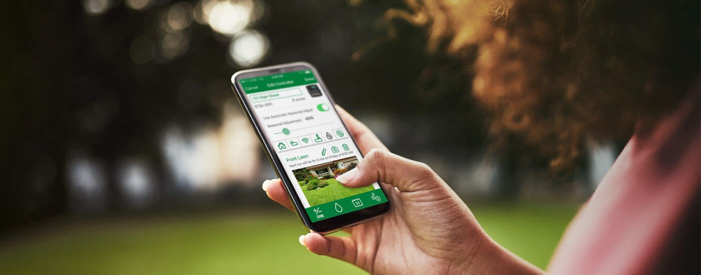 woman holding phone with Rain Bird App