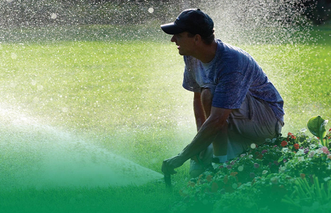 man adjusting sprinkler