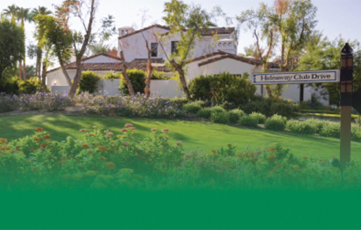 green front lawn in front of white villa house