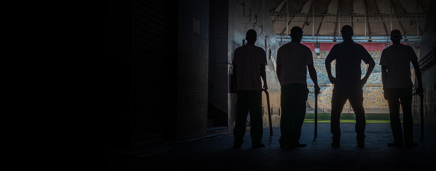 Silhouette of 4 guys at entrance of stadium